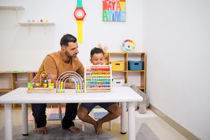 boy-playing-with-father-home-calculate-with-educational-toy