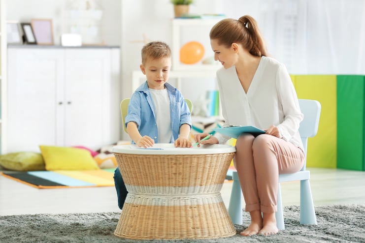 young-female-psychologist-working-with-little-boy-office
